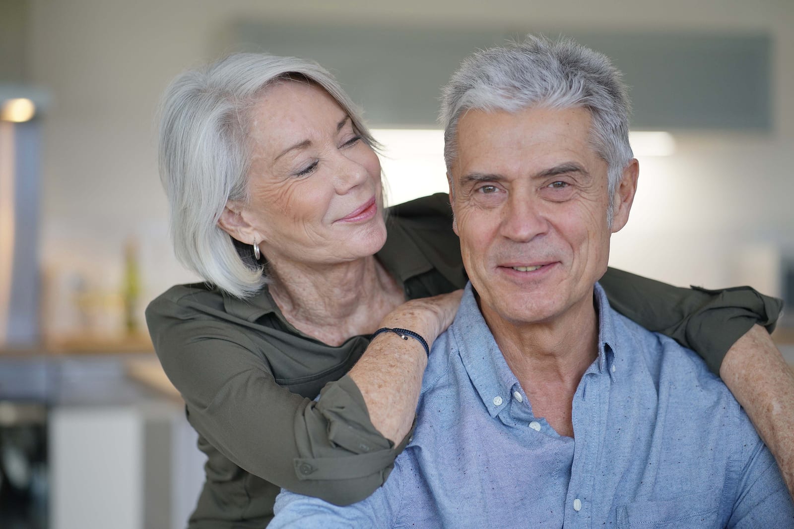 Portrait of loving senior couple in modern home